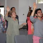 People with Hands Raised, Praising God. God Inhabits the Praises of His People.
